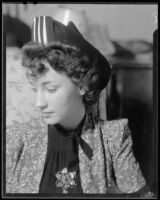 Woman with floral brooch and hat, 1940-1950