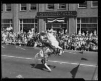 Leo Carrillo riding a rearing Palomino horse in the California Admission Day Parade, Santa Monica, 1937