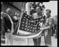 Two Boy Scouts and a third male holding an American flag at a Knights of Columbus flag presentation ceremony, Santa Monica, 1938