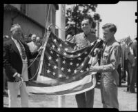 Two Boy Scouts and a third male holding an American flag at a Knights of Columbus flag presentation ceremony, Santa Monica, 1938