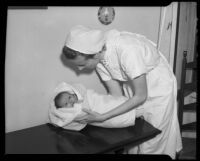 Nurse holding a swaddled baby at the Children's Home Society, Los Angeles, 1935-1960