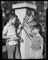 Boys holding U. S. flags as another boy salutes at the Children's Home Society, Los Angeles, 1935-1960