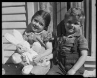 Girl with stuffed rabbit seated with boy at the Children's Home Society, Los Angeles, 1935-1960