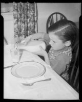 Boy pouring a glass of milk at mealtime at the Children's Home Society, Los Angeles, 1935-1960