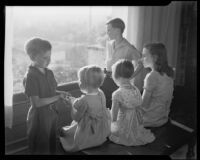 Five children seated on a bench beside a window at the Children's Home Society, Los Angeles, 1935-1960