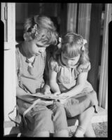 Two girls holding an illustrated page at the Children's Home Society, Los Angeles, 1935-1960