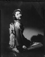 Alyce Asaka in traditional Japanese dress, seated on a bench, Santa Monica, 1940