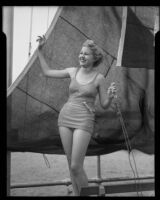 Model Jean Myras standing on or next to a sailboat on the pier, Santa Monica, 1935
