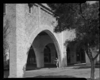Model Jean Myras standing beneath the arch of the Casa del Portico building at Malaga Cove Plaza, Palos Verdes Estates, 1936