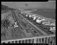 Young woman seated at the cliff edge in Palisades Park with PCH and Santa Monica Beach below, 1938-1950