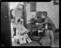 Santa Claus bringing presents to a boy and girl, Santa Monica, 1938