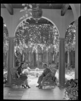 Owner Charles B. Hervey and a woman in the patio of El Mirasol Hotel, Santa Barbara, 1941