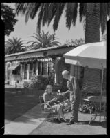 Charles B. Hervey and a woman on the outside of a bungalow at El Mirasol Hotel shortly after he became the owner, Santa Barbara, 1941