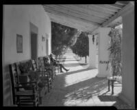 Guest relaxing in a covered walkway at La Quinta Hotel, Indio, circa 1940