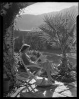 Carolyn Bartlett seated in a patio, perhaps at the Town House resort, Palm Springs, 1940