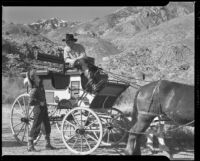 Betty Shafer stands next to a wagon conversing with a cowboy, Palm Springs vicinity, 1942