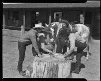 Cowboys playing cards in the corral at the Rogers Ranch resort, Palm Springs, 1942