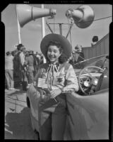 Woman in western attire next to an automobile the Desert Circus Rodeo held at the Palm Springs Field Club, Palm Springs, 1941