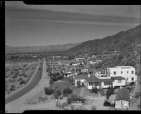Desert landscape view down a highway with houses on the right, Palm Springs, 1935