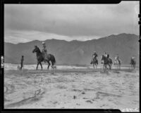 Cowboy leading vacationers on horseback in the desert en route to breakfast with The Desert Riders, Palm Springs vicinity, 1936