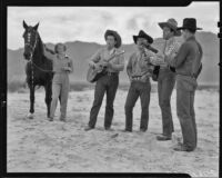 Cowboys singing and playing guitars during a Desert Riders tourist excursion, Palm Springs vicinity, 1936