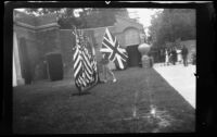 Student placing a Union Flag on a stand with other flags at the Memorial Greek Amphitheatre, Santa Monica, 1937-1939