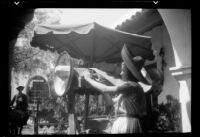Carolyn Bartlett wearing a sombrero at a market at the Old Spanish Days Fiesta, Santa Barbara, 1937