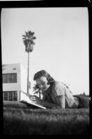 Student reading a book on the lawn of Santa Monica High School, Santa Monica, 1937-1939