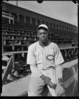 Baseball pitcher Satchel Paige seated next to bleachers, Los Angeles, circa 1933