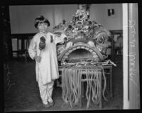 Mary Jane Fong holding a gong stick and standing next to a Chinese lion in Chinatown, Los Angeles, 1927