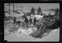 Sled dogs, men, cars, and toboggan in snow, preparing for recovery operation, June Lake, 1938