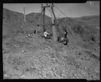Woman and man seated near electrical cables, near Parker, Arizona, 1934