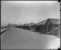 View down strand with beach tents and cottages towards the Hotel del Coronado, Coronado, circa 1920-1930
