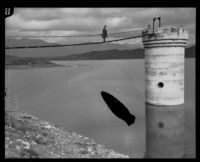San Fernando Reservoir with man on bridge to intake tower, Granada Hills, 1926
