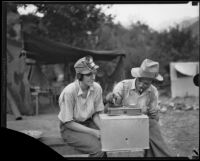 Gold miners Charles T. Brown and Mrs. Frank Robison weighing gold, San Gabriel Canyon, 1932