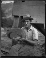 Gold miner Charles T. Brown with gold dust in pan, San Gabriel Canyon, 1932