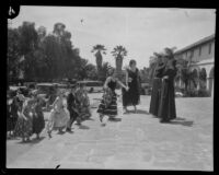 Dancers in the Old Spanish Days Fiesta greeted by Father Augustine in front of the Mission, Santa Barbara, 1930