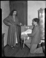 Mystic Meher Baba and kneeling man with suitcase, Hollywood, 1932