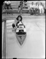 Ruth Bush displaying model speedboat in swimming pool, Los Angeles Boat Show, Los Angeles, 1930