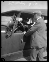 Official inspecting car, driver, and passenger during murder investigation, Los Angeles, 1923