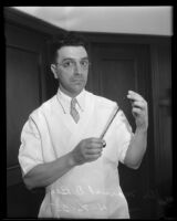 D. Marvel D. Beem holds a strip of film during an interview about his recent trip to Africa, Los Angles, 1935