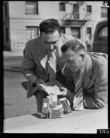 Detectives Thad Brown and Joe Filkas inspect fake bomb, Los Angeles, 1934