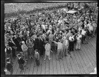 Spectators crowd a wharf and wave towards camera, Los Angeles, 1928