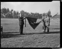 Frank A. Bouelle attaching a streamer award for the R.O.T.C. to a flag, Los Angeles, 1932