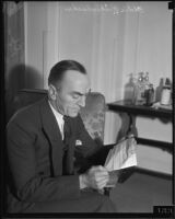 Veteran fighter pilot Eddie Rickenbacker reading a telegram, 1930s