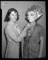 Otis Art Institute student Grace Mallon adjusts mask on fellow student Miriam Hazard before the annual student exhibition, Los Angeles, 1933