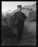 Admiral Coontz standing by a dirt road in front of a car, 1920s