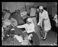 Two Red Cross workers sorting clothing donations for survivors of the flood following the failure of the Saint Francis Dam, Santa Clara River Valley (Calif.), 1928