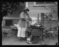 Woman cooking outside of her house after the Long Beach earthquake, southern California, 1933