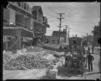 Clean-up crew beside building missing its facade after the Long Beach earthquake, Southern California, 1933